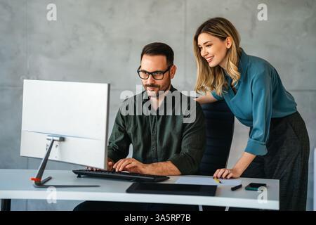 Business professionals collaborating on a project in a modern office. Team of coworkers sharing idea Stock Photo