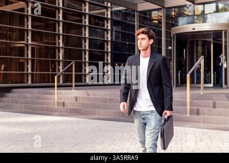 businessman walking in front of office building Stock Photo