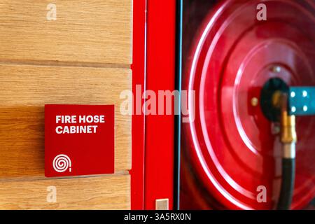 Fire Safety Concept, Fire extinguisher, Fire protection cabinet with fire hydrant and hose reel in public building corridor. Stock Photo