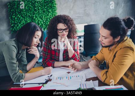 Focused team collaborating on business project in a modern coworking space with diverse professionals discussing plans and strategies Stock Photo