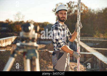 In white hardhat. Worker is on the construction site at daytime. Stock Photo