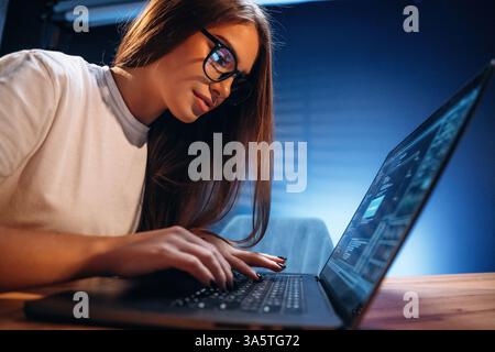 Female programmer, IT worker is sitting by the laptop. Stock Photo