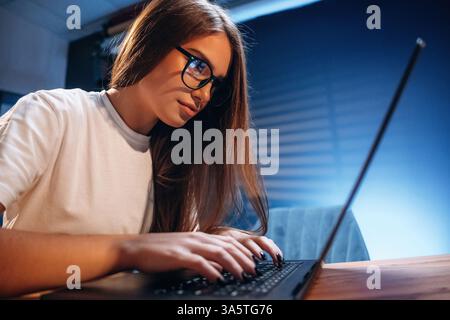 Female programmer, IT worker is sitting by the laptop. Stock Photo