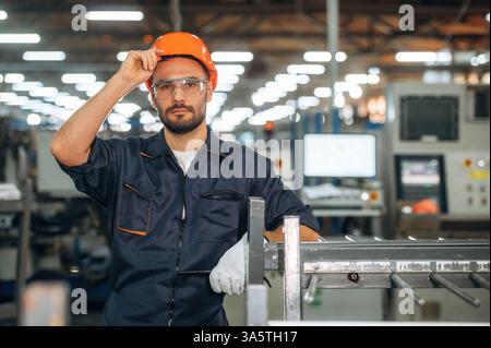In the orange colored hardhat. Man is working in the modern factory. Stock Photo
