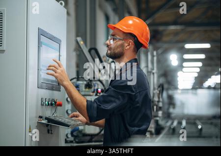 Operating the machine. Man is working in the modern factory. Stock Photo