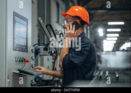 Operating the machine. Man is working in the modern factory. Stock Photo