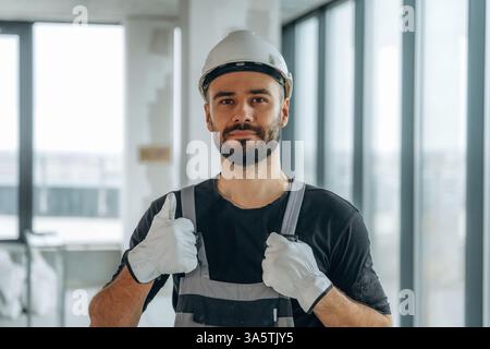 Showing thumb up. A man is renovating an unfinished room. Stock Photo