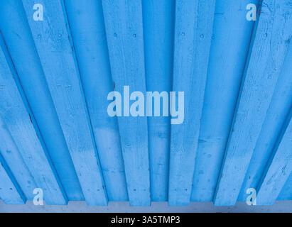 Close-up of a blue wooden fence with vertical planks, showing texture and grain. Stock Photo