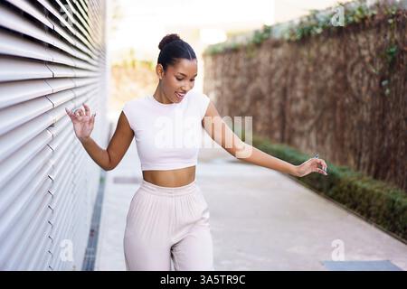 A Joyful, Young Woman Dancing Gracefully in a Vibrant Urban Setting Full of Life Stock Photo