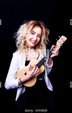 The Ukulele is a  Member of the guitar family. The ukulele, also called a uke, is a member of the lute family of instruments. The ukulele i Stock Photo
