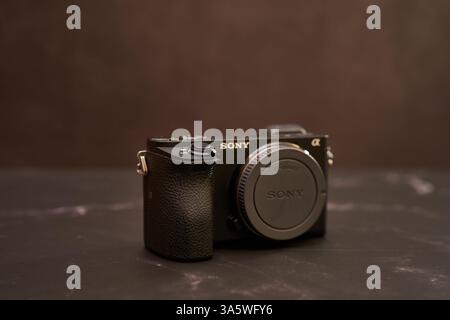 USA, Arizona - March 10, 2025: Sony A6300 digital mirrorless camera with a lens cap stands on a black marble table Stock Photo