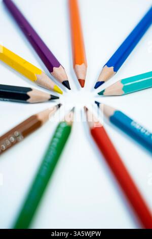 A Unique photo of pencil colors arranged in a circular pattern on a white background. Great for artistic and educational campaigns. Stock Photo