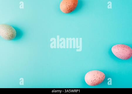 Four colorful speckled easter eggs on turquoise pastel background. Top view, flat lay, copy space. Stock Photo
