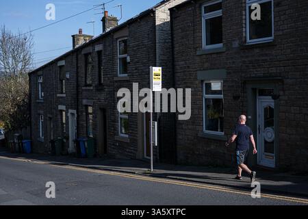 A man walks past a ‘Bee Network’ Bus Stop in the town of Mossley, Greater Manchester, UK. Stock Photo