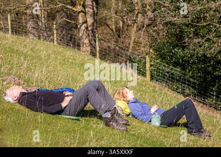 Couple enjoying a rest  break while out  on a long country  walk  walking in the Cheshire countryside Stock Photo