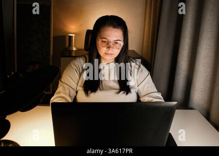 Focused businesswoman having virtual work meeting using laptop. Freelance worker sitting at home participates in video conference Stock Photo