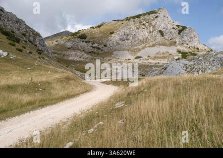 winding dirt road through mountain range of Dinaric Alps to Lake Orlovacko in Sutjeska National Park, Bosnia and Herzegovina Stock Photo