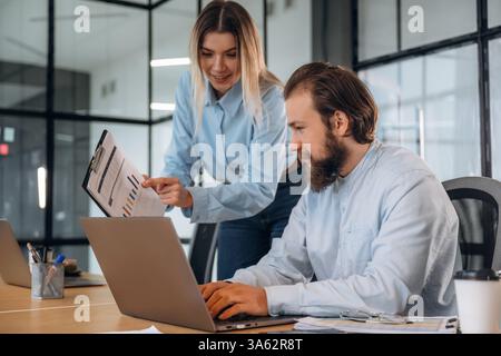 Successful, smiling and working. Man and woman are in the office together. Stock Photo