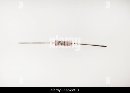 A brown resistor on a white background. The electronic component. Stock Photo
