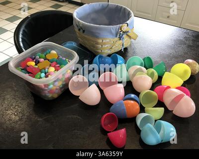 A pile of colorful Easter egg candy and chocolate on a brown table collected Easter morning. Stock Photo