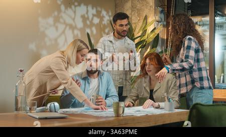 Multiracial multiethnic group coworking office team business women men girls guys male female students coworkers architects paperwork discussion Stock Photo