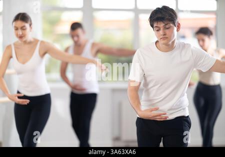 Young guy participating in group ballet class in choreography studio Stock Photo