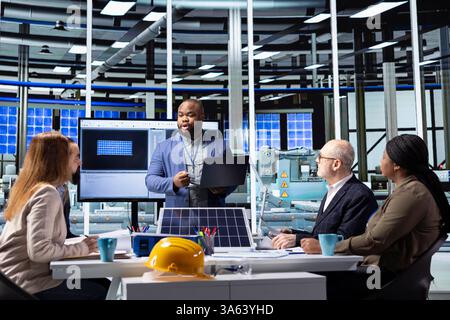 Investor presents manufacturing strategies and solar panel technology insights to factory management executives, using data to highlight sustainable growth opportunities in industrial production Stock Photo