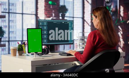 Freelancer interacting with smart AI virtual assistant next to mockup screen, using innovative chatbot web interface. Machine learning enhances productivity through advanced algorithms. Camera A. Stock Photo
