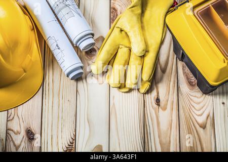 Blueprints helmet gloves and tool box on wood Stock Photo