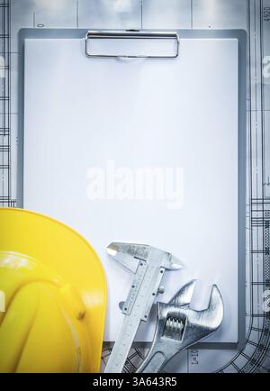 Clipboard building helmet adjustable spanner vernier caliper on blueprint construction concept Stock Photo
