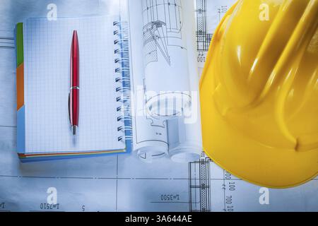 Safety building helmet checked notebook pen blueprints on construction plan Stock Photo