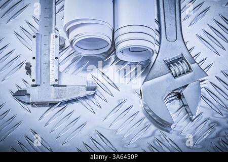 Construction plans vernier caliper adjustable wrench on grooved metal sheet maintenance concept Stock Photo