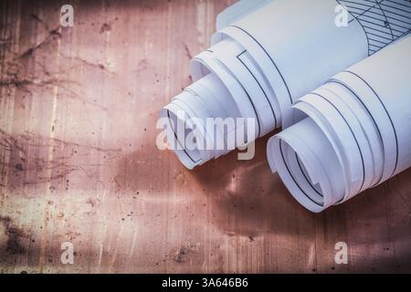 Rolled blueprints on brazen background construction concept Stock Photo
