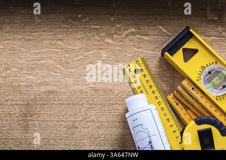 Blueprints and set of instruments of measurement on oak wood board construction concept Stock Photo