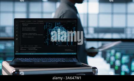 Artificial intelligence technology coding on laptop in data center with programmers in background employing machine learning models. Notebook used by AI IT experts, camera A close up Stock Photo