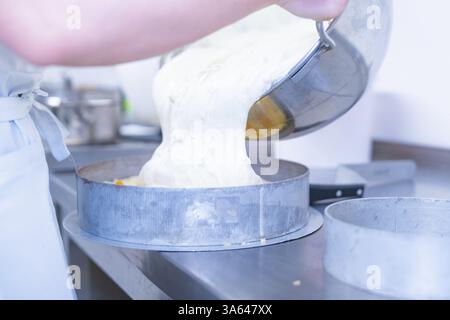 Dough is poured into a cake tin on a metal work surface, cake baking, Haselstaller Hof Cafe Kuh, Wildberg, Black Forest, Germany, Europe Stock Photo