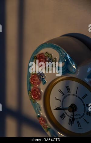 Rustic heart shaped clock in sun and shadow. Looking down vantage. Shot on shelf Stock Photo