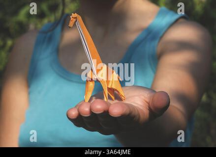 Origami orange color giraffe on hand Stock Photo