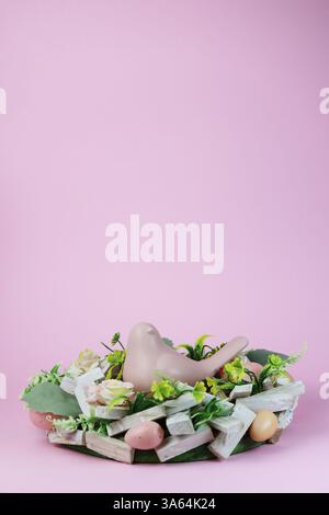 Easter nest with a chick and Easter eggs on a pink background Stock Photo