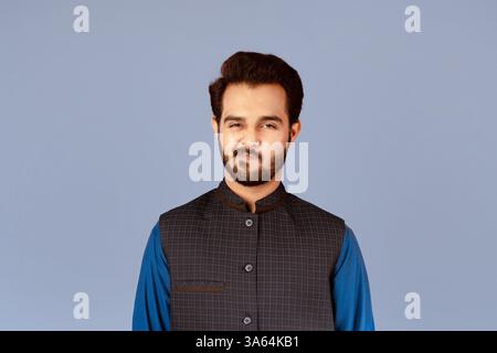 Handsome Indian guy expressing suspicion over violet background Stock Photo