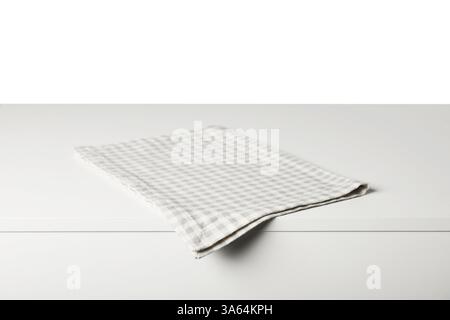 Checkered napkin on light table against white background Stock Photo