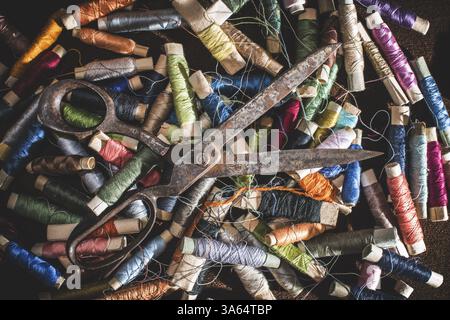 Old vintage scissors on spools of thread. Multicolored Stock Photo