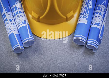Building helmet blue rolled blueprints on grey background construction ...