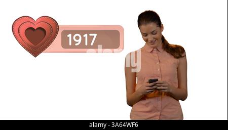 Smiling woman using smartphone, checking social media notifications with heart icon Stock Photo
