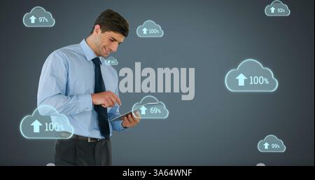Businessman using tablet with cloud computing icons, analyzing data trends Stock Photo