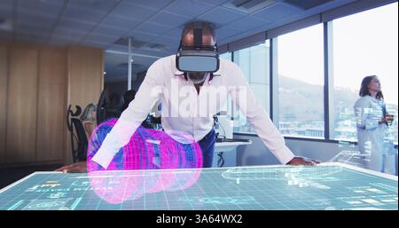 Man using VR headset interacting with holographic display in modern office Stock Photo