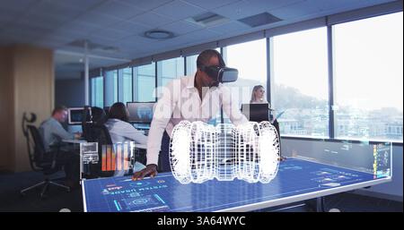 Using VR headset, engineer interacting with holographic interface in modern office Stock Photo