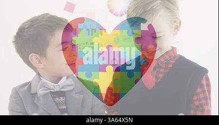 Two boys in school smiling and interacting with colorful puzzle heart overlay Stock Photo