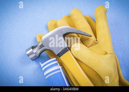 Claw hammer protective gloves rolled up construction drawings on blue ...