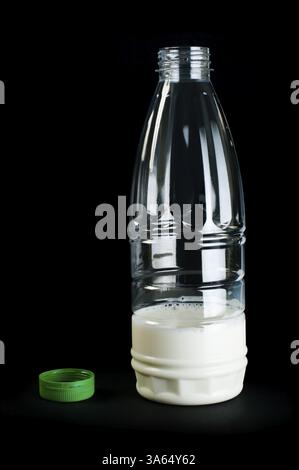 Plastic transparent bottle with milk. Green cap. Black isolated Stock Photo